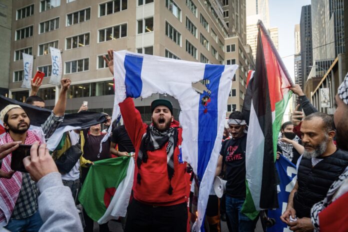 NEW YORK, UNITED STATES - May 15, 2021: Pro-Palestinian protesters burn Israeli flag in New York
