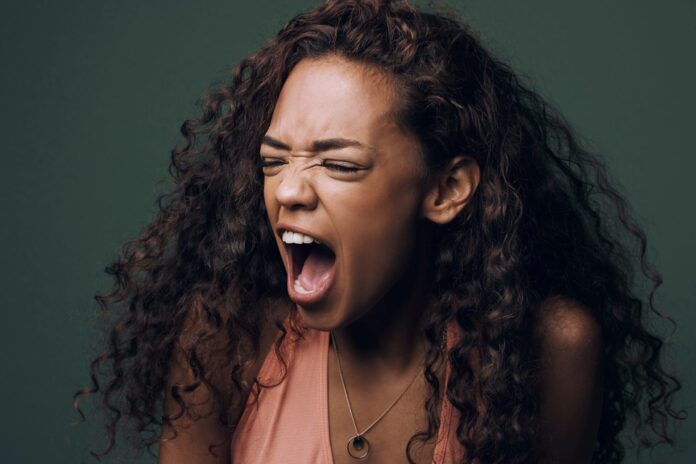 Stress, anxiety and angry woman scream in studio for fear, mistake or psychology crisis on green background. Depression, trauma and anger by female frustrated with mental health problem, fail or ptsd